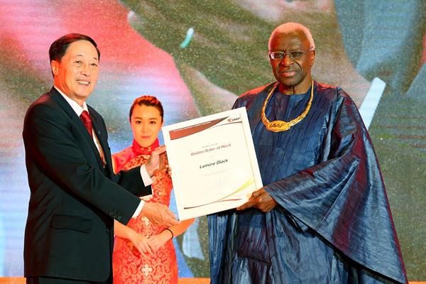 Former IAAF Vice President Lou Dapeng presents IAAF President Lamine Diack with the IAAF Golden Order of Merit at the Opening Ceremony and Dinner for the 50th IAAF Congress at the Great Hall of the People in Beijing (Getty Images)