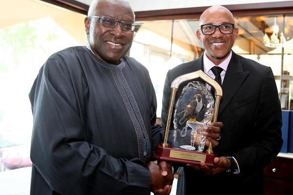 IAAF president Lamine Diack presents Frankie Fredericks with a commemorative crystal trophy (Laurel)