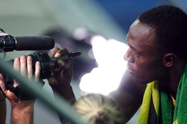 Usain Bolt of Jamaica signs a camera lens after winning the gold medal in the men's 4x100m at the 12th IAAF World Championships in Athletics (Getty Images)
