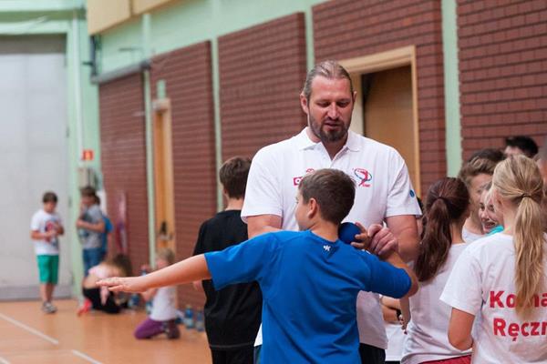 Tomasz Majewski instructs a child how to putt the shot (Organisers)