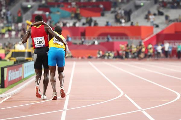 Braima Suncar Dabo helps Jonathan Busby to the finish of the their heat in the 5000m at the World Athletics Championships Doha 2019 (Getty Images)