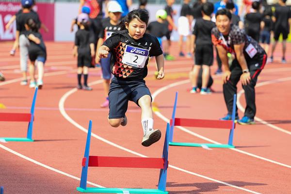 A school girl jumps over a hurdle at the Asics Kids Decathlon Challenge in Yokohama (Roger Sedres)