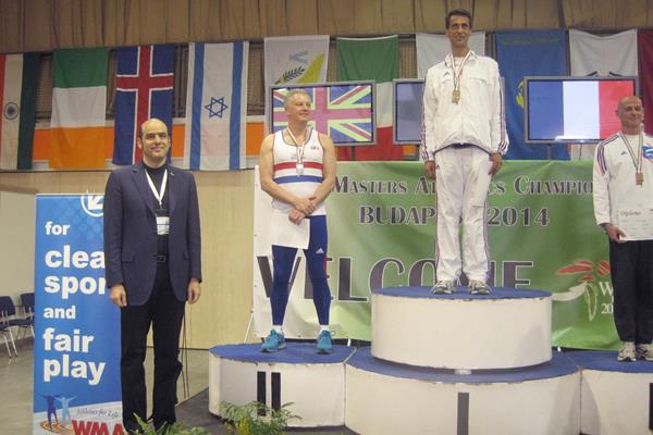 IAAF general secretary Essar Gabriel presents the medals for the M50 pole vault at the World Masters Indoor Championships in Budapest (Organisers)