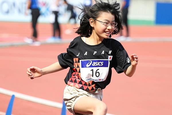 A school girl jumps over a hurdle at the Asics Kids Decathlon Challenge in Yokohama (Roger Sedres)