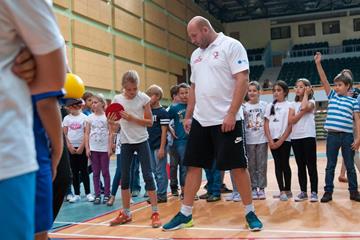 Piotr Malachowski teaching children the basics of the discus (Organisers)